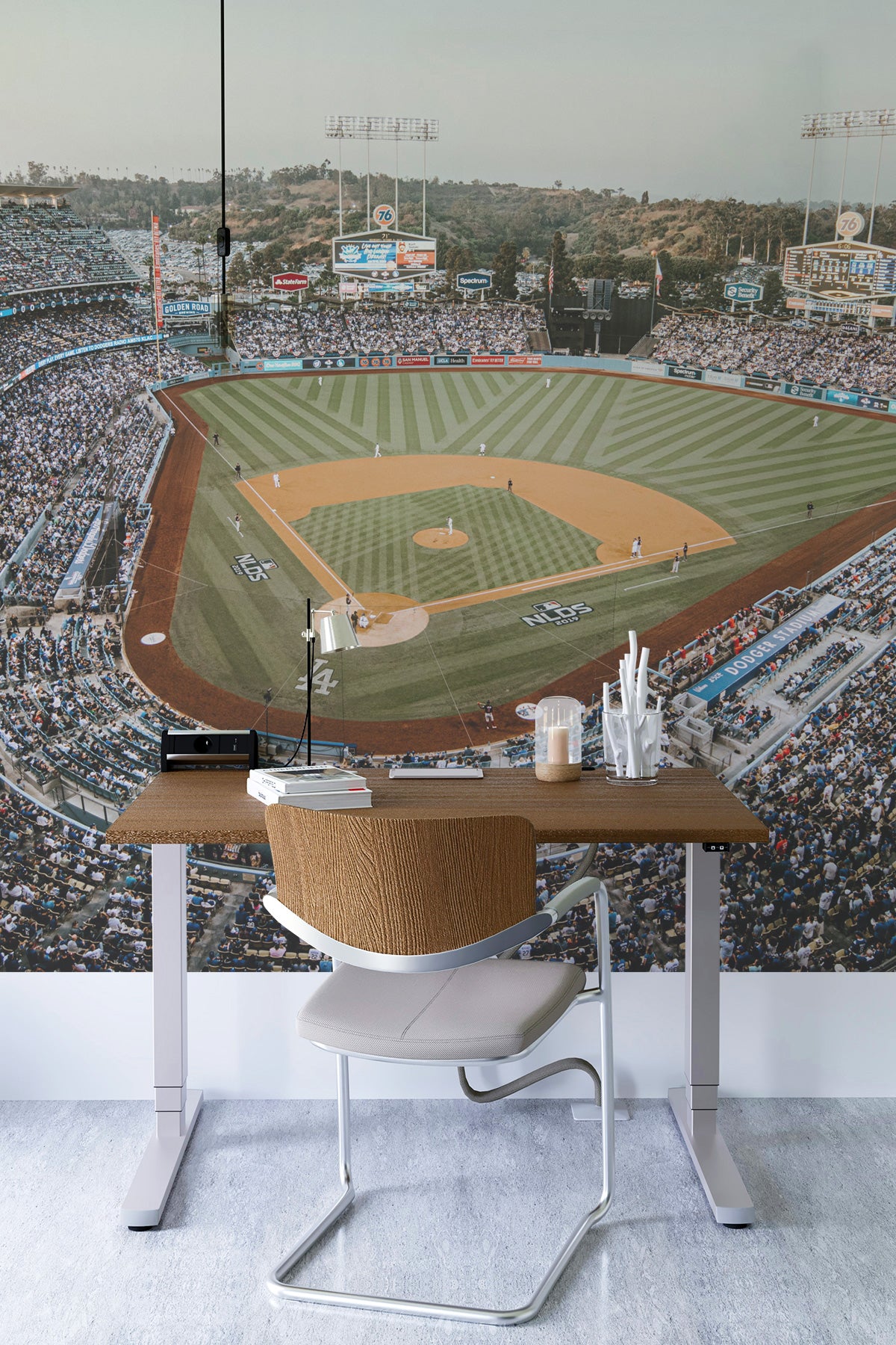 Desk setup with a chair in front of a large mural of a baseball stadium.