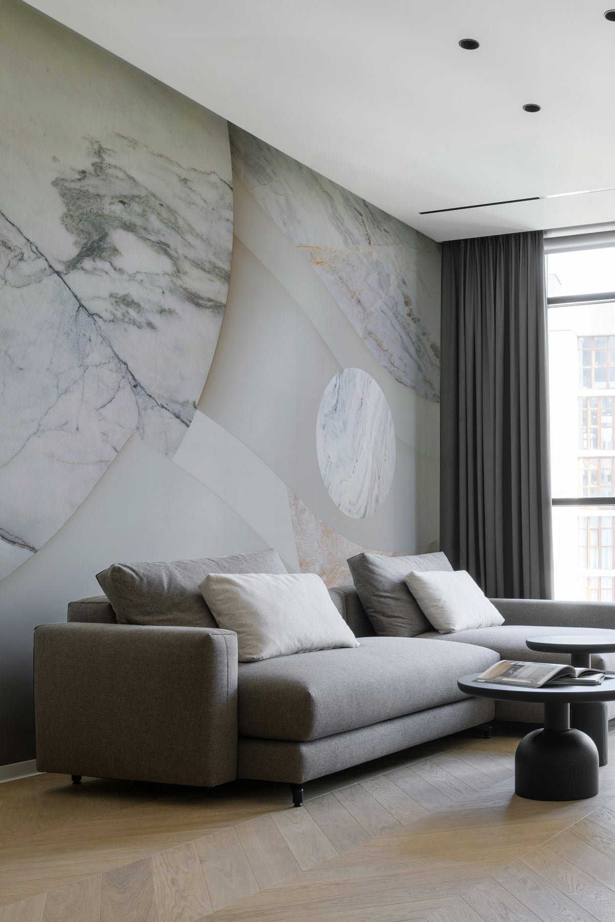 Astra Veil / Marble wall mural showcased in a Modern living room with a gray sectional sofa.
