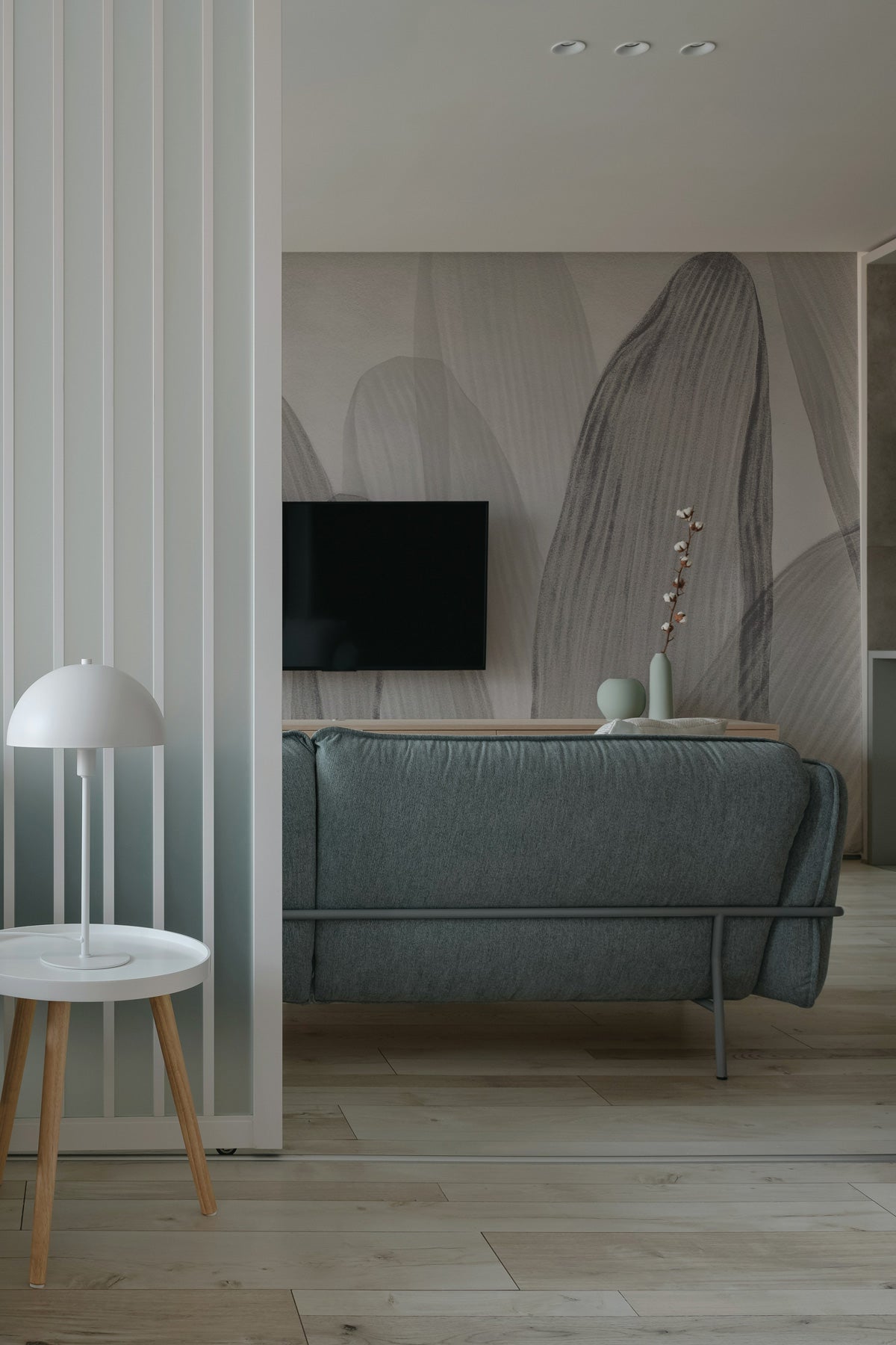 Elowen / Graphite wall mural in a modern living room with a gray sofa, TV, and decorative elements.