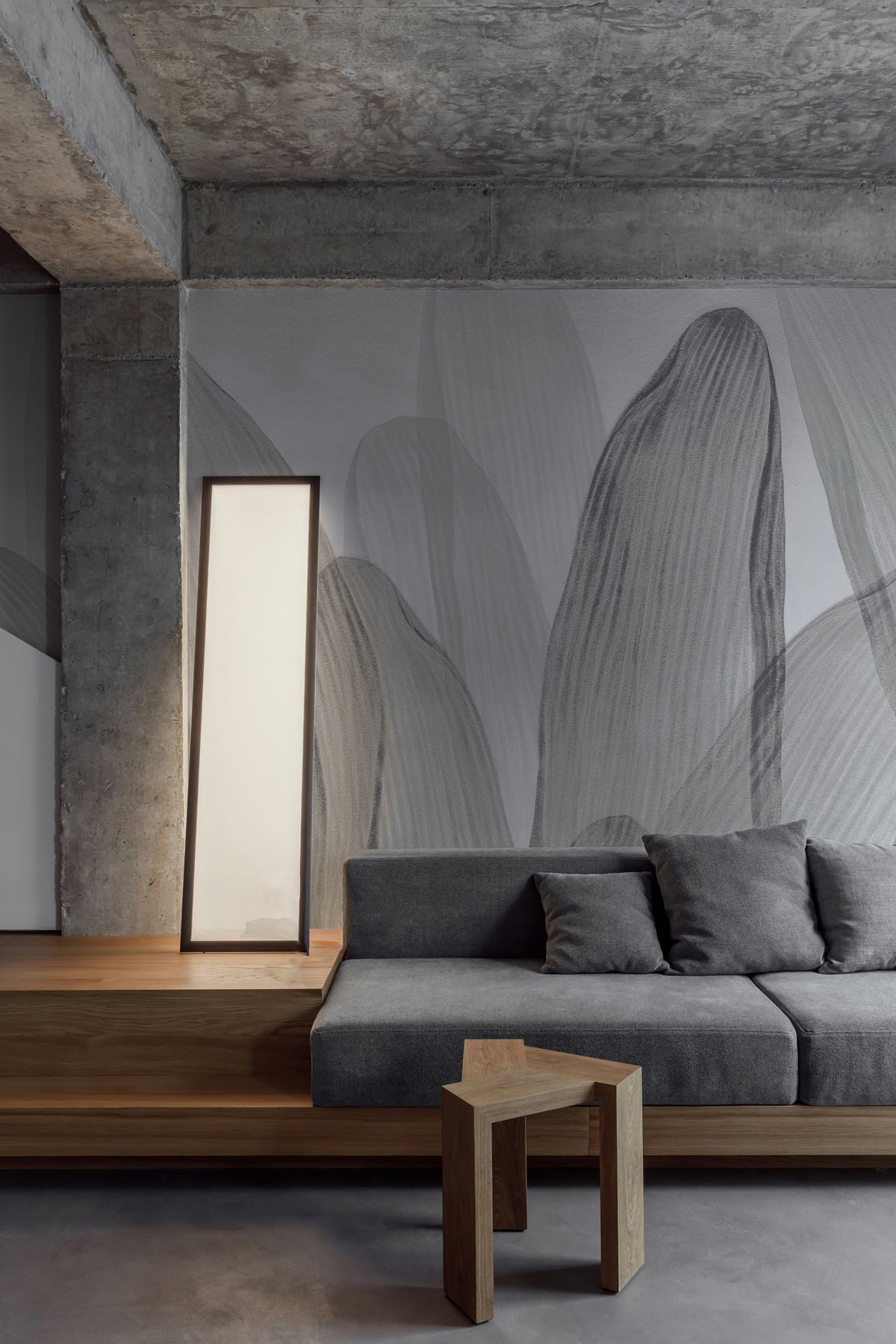 Elowen / Graphite wall mural in a modern living room with gray sofa and wooden side table.
